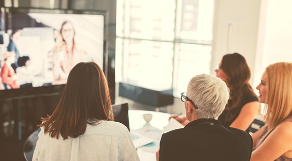 在大屏幕上观看网络研讨会的上班族