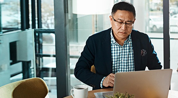 中年绅士在笔记本电脑屏幕上阅读