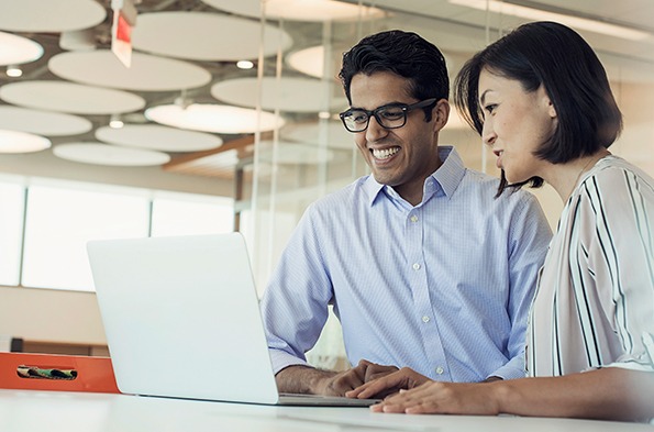 两个同事一起用笔记本电脑工作