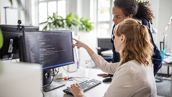 两名工程师在屏幕上查看代码