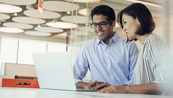 两个同事一起用笔记本电脑工作