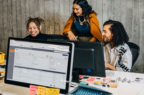 三个人聚集在一个电脑显示器周围