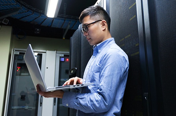 在数据中心拿着笔记本电脑的网络工程师