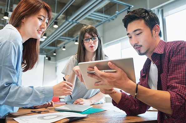 年轻人围坐在桌子前进行头脑风暴