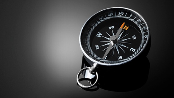 Black and silver compass on a black surface
