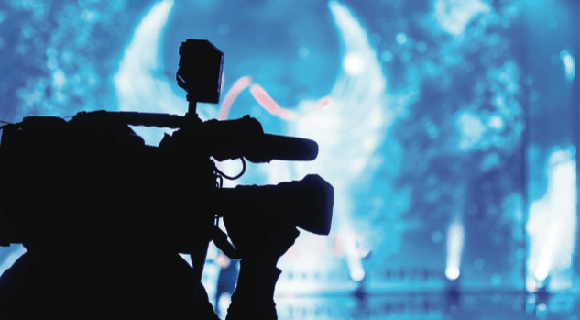 Silhouette of camera person in front of stage