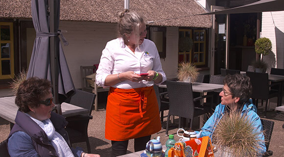 女服务员在Molecaten用电话接受用餐者的点菜