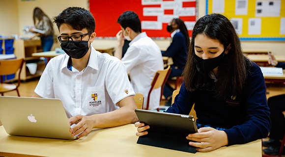 A student on a laptop and a student on a tablet device