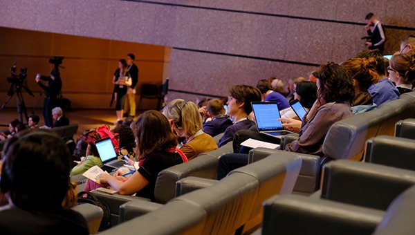 Conference attendees using wireless devices in their seats