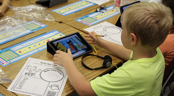 A student using a tablet in a classroom