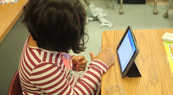 A student using a tablet in a classroom