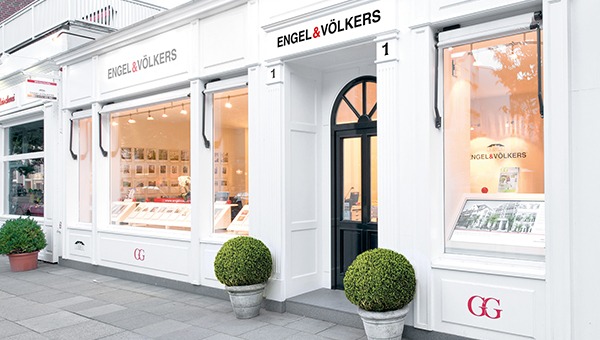 Real estate listings visible through the windows of the Engel & Völkers office