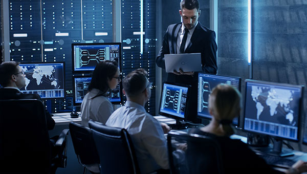 People working on multiple monitors/workstations at a government control center