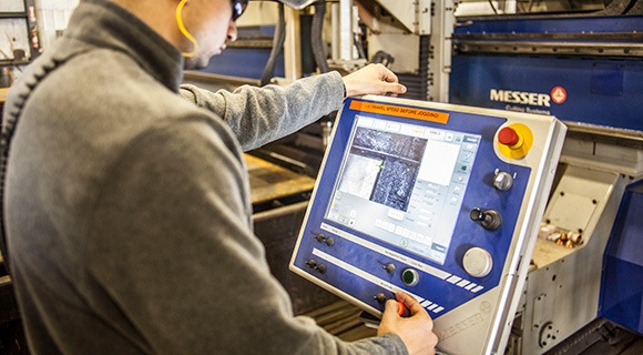 Factory worker at a machine screen
