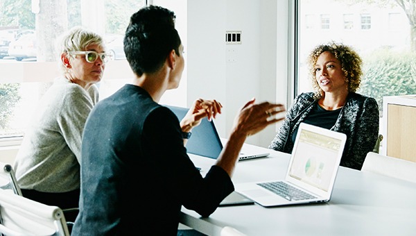 三个办公室职员在会议室里谈话